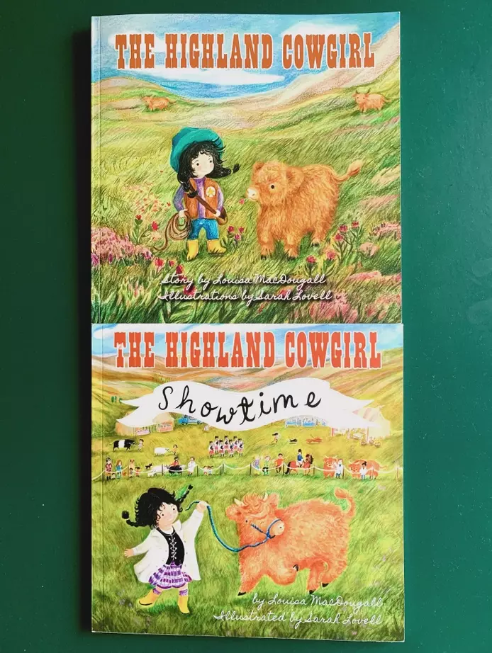 A photo of two picture books , both written by Louisa MacDougall, illustrated by Sarah Lovell and published by Foggie Toddle Books. The Highland Cowgirl and the Highland Cowgirl Showtime. Both books show an illustration of a girl with dark hair in plaits.